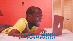 🔥 When AI Hits Just Right 🔥 GIF - a young Black man in yellow T-shirt lying on bed, excitedly typing on laptop. His face lights up as he reacts to his screen. The words "YAAAAASSS" appear in bold blue letters, emphasizing his excitement. GIF follows "How This Works" section.